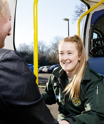 Female paramedic helping patient into ambulance