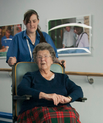 Female in uniform transporting an elderly female in wheelchair