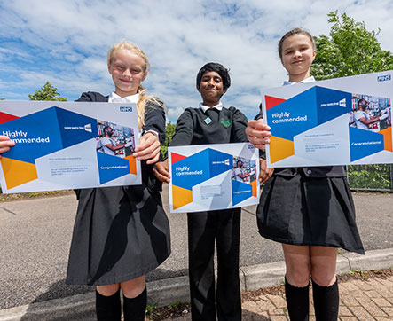 Three students holding certificates Three students holding certificates