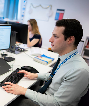 Male sitting at desk looking at computer