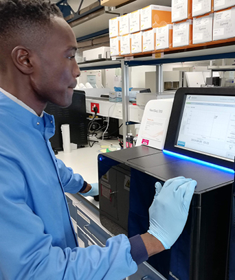 Male in scrubs looking at computer in laboratory