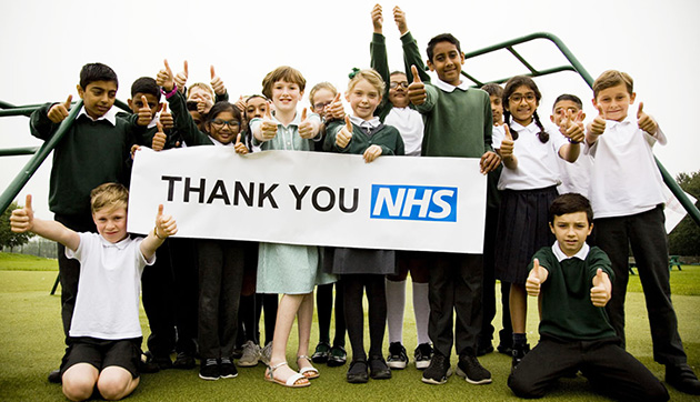 Primary school pupils holding 'Thank you NHS' sign