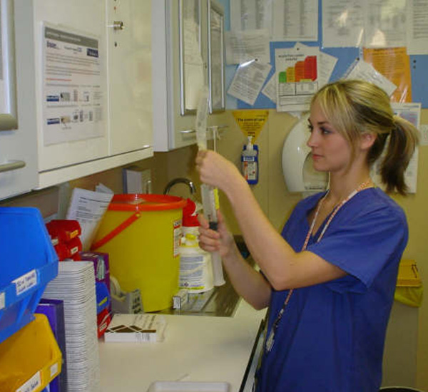 Female nurse preparing treatment at counter