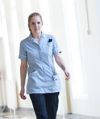 Female in uniform walking down hospital corridor