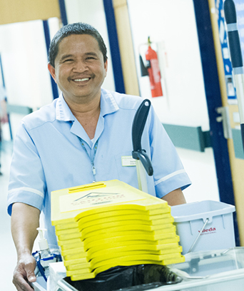 Male housekeeper transporting goods on trolley