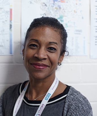 Female standing in front of notice board smiling at camera